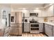 Modern kitchen with stainless steel appliances including double oven, stylish two-tone cabinets, and quartz countertops at 6238 S Cherry Cir, Centennial, CO 80121