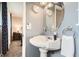 A charming powder room includes a pedestal sink, oval mirror, and view into bedroom at 6238 S Cherry Cir, Centennial, CO 80121