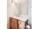 Bathroom featuring a wooden vanity with a white countertop, tiled backsplash, and modern fixtures at 16366 E Fremont Ave # 11, Aurora, CO 80016