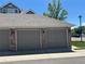 Two-car detached garages with brick accents and gray doors in a well-maintained community at 16366 E Fremont Ave # 11, Aurora, CO 80016