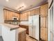 Efficient kitchen with wood cabinets, tile countertops, and white appliances at 16366 E Fremont Ave # 11, Aurora, CO 80016