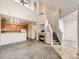 Inviting living room featuring a cozy fireplace, open staircase, and access to the kitchen at 16366 E Fremont Ave # 11, Aurora, CO 80016