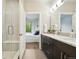 Bright bathroom featuring a shower, double sink vanity, and open doorway to the bedroom at 6619 E Lowry Blvd # 101, Denver, CO 80230