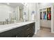 Modern bathroom showcasing double sinks, quartz countertop, dark cabinets, glass shower and closet at 6619 E Lowry Blvd # 101, Denver, CO 80230