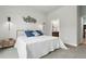 Bright bedroom featuring a white queen bed, accent wall decor, and ensuite bathroom at 6619 E Lowry Blvd # 101, Denver, CO 80230