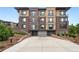 Contemporary brick building with a private entrance to a parking garage and beautifully landscaped grounds at 6619 E Lowry Blvd # 101, Denver, CO 80230