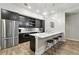 Modern kitchen features stainless steel appliances, stylish island with seating, and dark cabinets at 6619 E Lowry Blvd # 101, Denver, CO 80230