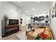 This living room features wood flooring, a comfortable leather couch, and an open floor plan into the kitchen at 6619 E Lowry Blvd # 101, Denver, CO 80230