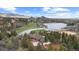 Stunning aerial view of a lakeside home next to golf course with beautiful mountain views and an inviting exterior at 7267 Comanche Ct, Larkspur, CO 80118