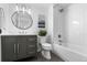 Bathroom with stylish vanity, round mirror and bathtub shower with white subway tile at 7267 Comanche Ct, Larkspur, CO 80118