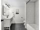 Modern bathroom features white vanity, new mirror and lighting, with a shower/tub and white tile at 7267 Comanche Ct, Larkspur, CO 80118
