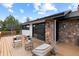 Exterior view of home's deck featuring outdoor seating areas and stone details at 7267 Comanche Ct, Larkspur, CO 80118