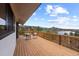 Open deck with chairs that overlooks serene lake and mountain views with lush natural setting on a bright sunny day at 7267 Comanche Ct, Larkspur, CO 80118