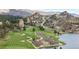 Scenic golf course with lush green fairways, mature trees, and serene water features nestled in a mountain landscape at 7267 Comanche Ct, Larkspur, CO 80118