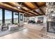 Open-concept living room featuring a stone fireplace, wood-beamed ceilings, and scenic mountain views at 7267 Comanche Ct, Larkspur, CO 80118