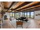 Cozy living room featuring a stone fireplace, wood-beamed ceilings, and expansive scenic views at 7267 Comanche Ct, Larkspur, CO 80118