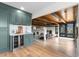 An open living area featuring custom cabinets, a wine fridge, and a view into the living room at 7267 Comanche Ct, Larkspur, CO 80118