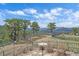 Backyard landscape with mature trees and mountains in distance at 1015 Nob Hill Rd, Evergreen, CO 80439