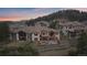 Aerial view of home with a tiered backyard, patio and balcony overlooking a wooded landscape at 1015 Nob Hill Rd, Evergreen, CO 80439