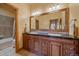 Bathroom featuring a double vanity with granite countertop and large mirror with decorative lighting at 1015 Nob Hill Rd, Evergreen, CO 80439
