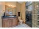 Bathroom featuring a glass-enclosed shower and a vanity with dark countertops and storage at 1015 Nob Hill Rd, Evergreen, CO 80439