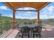 Covered deck features stone pillars and wrought iron furniture with mountain views at 1015 Nob Hill Rd, Evergreen, CO 80439