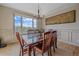Dining room boasts large window with mountain views and stylish chandelier at 1015 Nob Hill Rd, Evergreen, CO 80439