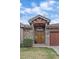 Close up exterior featuring stone accents, manicured landscaping, and a wooden door at 1015 Nob Hill Rd, Evergreen, CO 80439