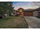 Beautiful home exterior with a wooden garage door, stone accents, and manicured front lawn at 1015 Nob Hill Rd, Evergreen, CO 80439