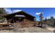 Inviting cabin featuring a wood deck, hexagon window, and wooded surroundings for peaceful living at 11798 Sidney Rd, Golden, CO 80403
