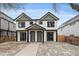 Modern duplex with white siding, black trim, green accents, and inviting curb appeal at 2430 Ames St, Edgewater, CO 80214