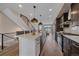 Open kitchen with a large island, stainless steel appliances, and modern pendant lighting at 2430 Ames St, Edgewater, CO 80214