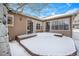 Spacious backyard patio with snow covering, ideal for outdoor relaxation at 810 Meadow Run, Golden, CO 80403