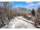 Icy creek with walking path and snowy trees at 810 Meadow Run, Golden, CO 80403