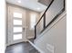 Inviting entryway with wood-look floors, a modern front door, and a stylish staircase leading to the upper level at 2648 Mayotte Way, Castle Rock, CO 80109