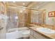 Elegant bathroom featuring a tiled shower and bathtub, paired with a white vanity and sink with gold-toned fixtures at 1900 E Girard Pl # 608, Englewood, CO 80113