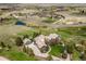 Aerial view of a large home surrounded by mature trees, a pond, and a winding driveway, set in a lush landscape at 4749 Starfire Cir, Castle Rock, CO 80104