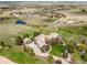 Drone-eye home view nestled in a lush landscape with a pond and rolling hills at 4749 Starfire Cir, Castle Rock, CO 80104