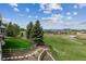 Lush backyard featuring a green lawn, wooden fence, mature trees, and a distant view of rolling hills and mountains at 4749 Starfire Cir, Castle Rock, CO 80104