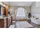 Elegant bathroom with a freestanding tub, dark tile floors, dual vanities, and a large window dressed with beautiful, decorative curtains at 4749 Starfire Cir, Castle Rock, CO 80104