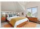 Cozy bedroom with a vaulted ceiling, natural light, a wood bed frame, neutral colors, and modern decor for a relaxing atmosphere at 4749 Starfire Cir, Castle Rock, CO 80104