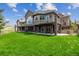 Expansive home showcasing a covered patio with stone pillars, complemented by a lush green lawn on a sunny day at 4749 Starfire Cir, Castle Rock, CO 80104