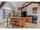 Open-concept kitchen with a wooden island, granite countertops, and black appliances at 4749 Starfire Cir, Castle Rock, CO 80104