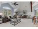 Bright living room with vaulted ceilings, a ceiling fan, neutral paint, large windows, and comfortable seating for entertaining guests at 4749 Starfire Cir, Castle Rock, CO 80104