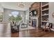 Bright living room with floor to ceiling windows, a stone fireplace, and hardwood floors at 4749 Starfire Cir, Castle Rock, CO 80104