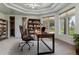 Bright home office featuring a large industrial desk, built-in shelving, natural light, and an ergonomic chair for comfort and productivity at 4749 Starfire Cir, Castle Rock, CO 80104