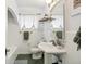 Bright, all-white bathroom featuring tiled walls, a pedestal sink, and an arched alcove with a bathtub at 3055 N Albion St, Denver, CO 80207