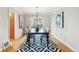 An inviting dining room features hardwood floors, an elegant chandelier and a stylish black and white rug at 3055 N Albion St, Denver, CO 80207