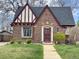 Quaint brick Tudor home featuring a unique roofline and well-kept front yard at 3055 N Albion St, Denver, CO 80207