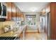 The kitchen boasts a stainless steel refrigerator, hardwood floors, updated cabinets and a window over the sink at 3055 N Albion St, Denver, CO 80207